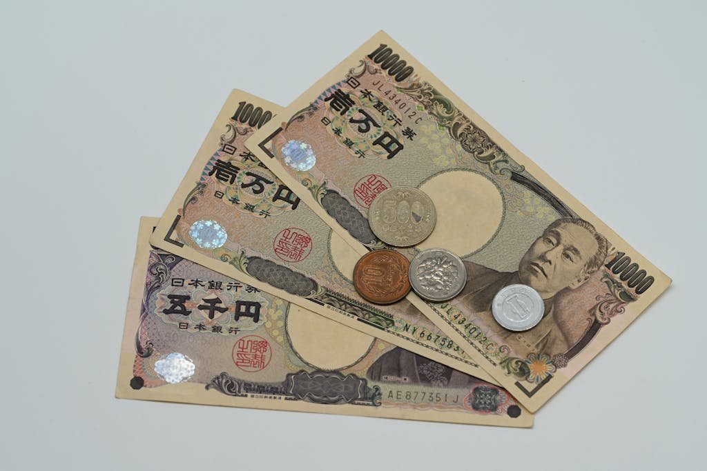 Close-up of Japanese Yen banknotes and coins arranged on a flat surface.