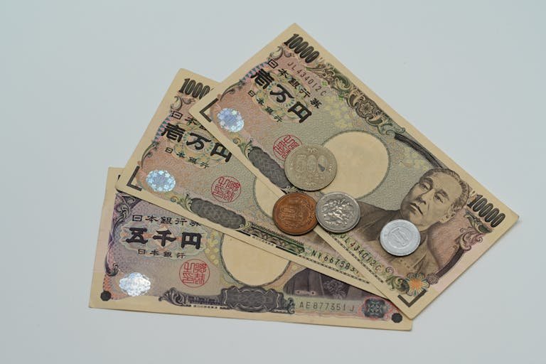 Close-up of Japanese Yen banknotes and coins arranged on a flat surface.